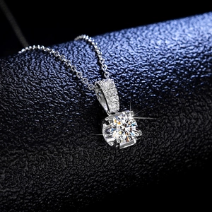 Gros plan du pendentif en moissanite taille ronde avec bélière pavée et chaîne en argent