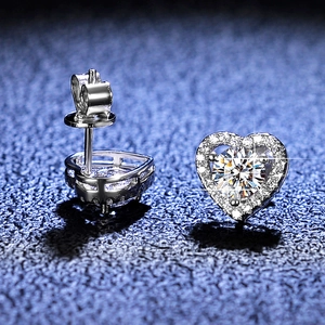 Macro detail of heart-shaped S925 sterling silver moissanite stud earrings with pavé halo