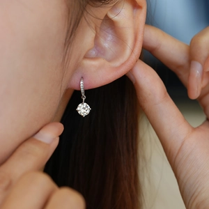 Elegant silver pendant drop earring with sparkling round-cut moissanite worn by a model