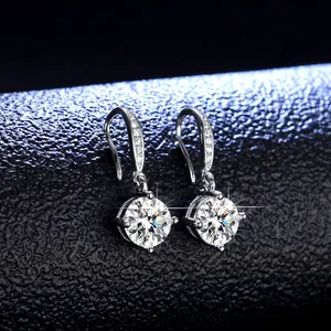 Macro shot of silver drop earrings featuring brilliant round cut stones and four-prong setting