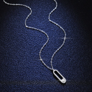 Collier épingle à nourrice en argent S925 avec pendentif moissanite sur fond bleu texturé