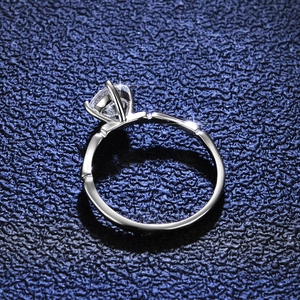 Polished silver moissanite ring featuring a unique bamboo style band and claw setting