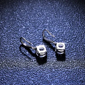 Macro detail of S925 silver ear hooks with four-prong set brilliant cut moissanite stones