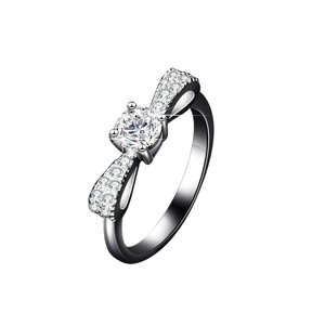 Macro detail of silver bow ring featuring a round center stone and pave accents