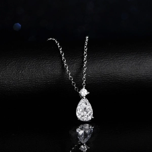 Elegant silver necklace with a pear-cut blue topaz stone and moissanite diamond pendant