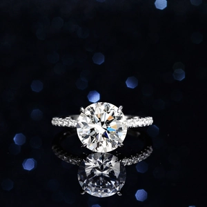 Classic 4-prong S925 sterling silver ring featuring a 5-carat round moissanite with pavé band