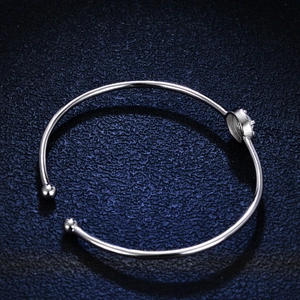Bracciale rigido in argento 925 lucido con moissanite a castone su sfondo blu scuro