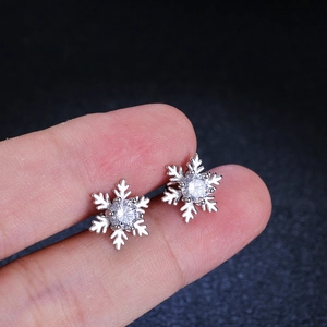 Handheld view of elegant S925 sterling silver snowflake earrings with moissanite stones