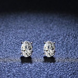 Macro detail of oval cut moissanite silver earrings with classic four-prong setting