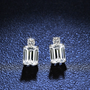 Elegant S925 silver emerald cut earrings with brilliant round accents on blue leather