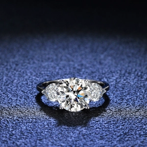 Classic 3-carat heart Moissanite silver ring with round cut stones on a deep blue background