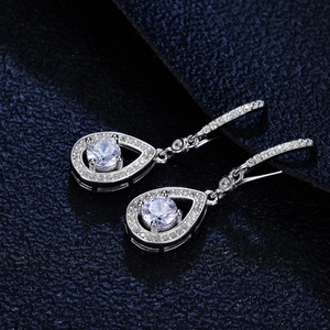 Elegant S925 silver moissanite drop earrings with pear halo design on blue velvet