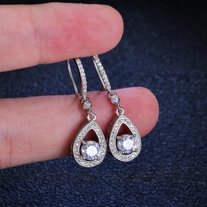 Elegant S925 silver pear-shaped drop earrings with moissanite, held by hand