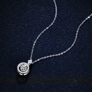 Elegant 925 sterling silver necklace featuring 1 carat round moissanite pendant on blue fabric