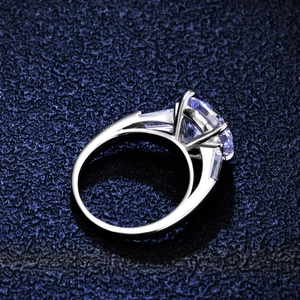 Classic 4-claw S925 silver 5 carat moissanite ring with side diamonds on blue background