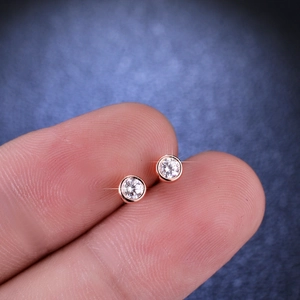Minimalist S925 rose gold bezel set moissanite stud earrings shown on fingertip