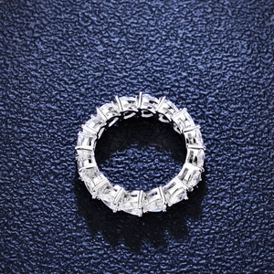 Eternity ring in S925 silver with sparkling moissanite stones on a blue background
