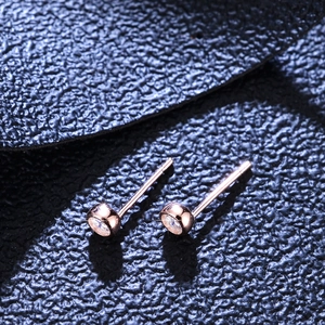 Classic S925 rose gold bezel set moissanite stud earrings on dark textured background