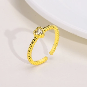 Dettaglio macro dell'anello regolabile dorato con fascia a sfere e zircone a cuore