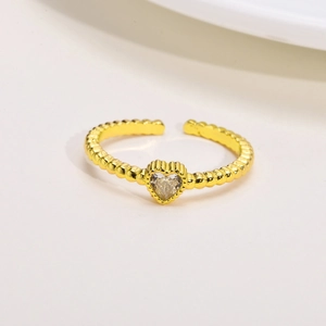 Dettaglio anello dorato regolabile con trama a perline e zircone a forma di cuore