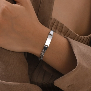 Dettaglio di un bracciale in maglia d'acciaio inossidabile argento con placca incisibile