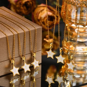 Detail of golden stainless steel star pendants with shell inlay and various initials