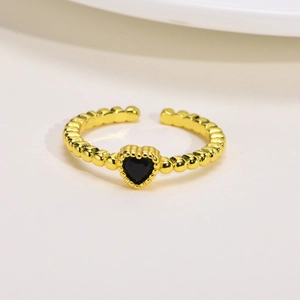 Dettaglio di anello regolabile a sfere dorate con zircone nero a forma di cuore