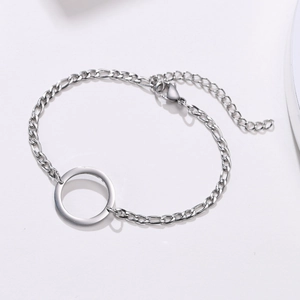 Macro shot of silver stainless steel Figaro chain bracelet featuring a polished hollow ring