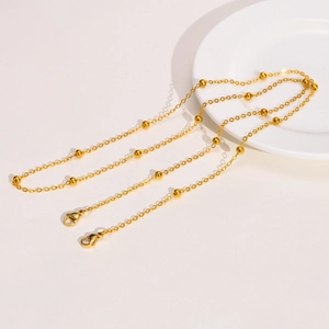 Detail of gold bead chain with lobster clasps for glasses or face masks on white background
