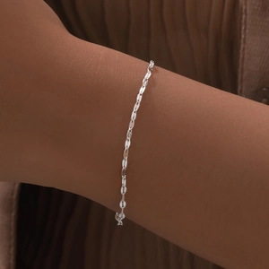 Detailed close-up of a minimalist silver-tone flat oval link chain bracelet on wrist