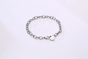 Détail du bracelet chaîne à maillons plats en acier inoxydable avec pendentif rond et fermoir