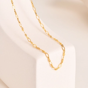 Détail d'une chaîne minimaliste à maillons ovales allongés en acier plaqué or 18K