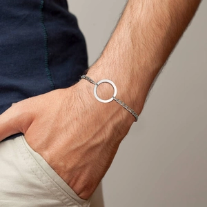 Macro shot of men's stainless steel circular ring link bracelet on male wrist