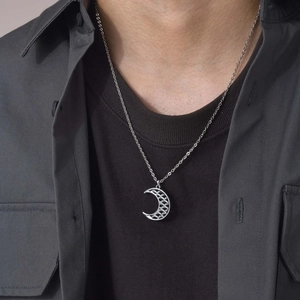 Close-up of men wearing silver crescent moon pendant with intricate hollow scale pattern