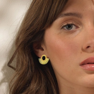 Art Deco style gold fan earrings with black onyx stone shown on female model