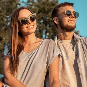 Detailed view of couple wearing matching sun and moon puzzle pendants in silver finish