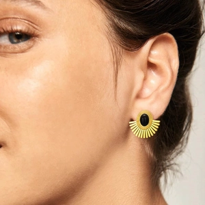 Golden sunburst fan earrings with black onyx inlay shown on a model ear lobe