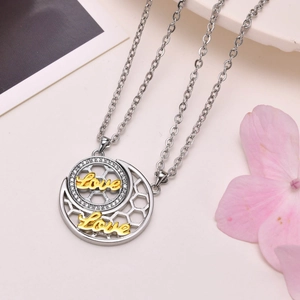 Macro detail of sun and moon couple necklace with Love engraving and zircon inlay