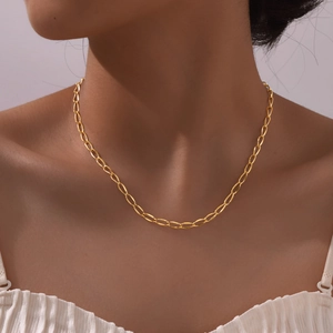 Close-up of golden paperclip link necklace on a model with elegant minimalist aesthetic