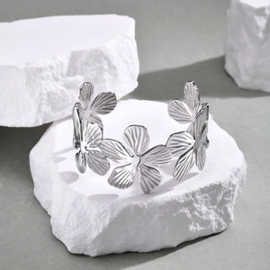 Vista dettagliata del bracciale a fascia irregolare con fiori in acciaio su pietra