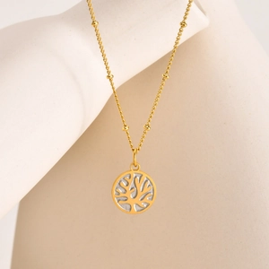 Détail d'un pendentif rond doré avec motif de corail sur un support artistique