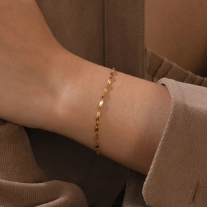 Minimalist 18K gold rectangle link chain bracelet displayed on a female wrist