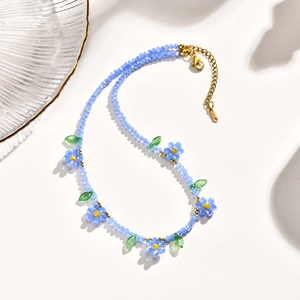 Vue macro du collier de perles marguerites bleues avec cristaux et fermoir doré