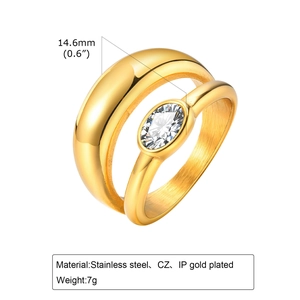 Detail of gold stainless steel ring set featuring a wide band and oval CZ stone setting