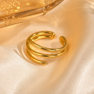 Macro shot of gold three-layer spiral ring on luxury champagne silk fabric detail