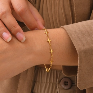Gros plan des maillons dorés du bracelet en forme d'étoile sur le mannequin en détail
