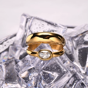 Detail of a double-layered gold stainless steel ring with an oval zircon on ice