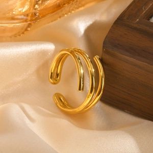 Macro shot of three-layer spiral gold open ring on champagne satin and wood base