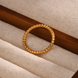 Minimalist geometric gold stainless steel ring with honeycomb texture shown on display