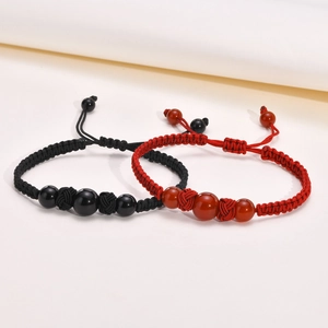 Detail of handmade woven bead bracelets in red and black with adjustable cords